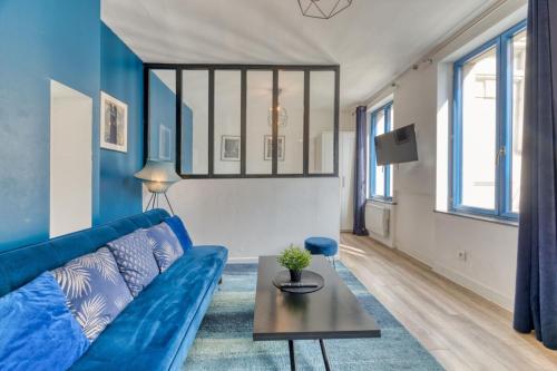 un salon avec un canapé bleu et une table dans l'établissement Le BlueArt votre logement au cœur de Rouen, à Rouen