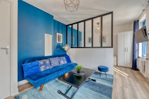 un salon bleu avec un canapé bleu et une table dans l'établissement Le BlueArt votre logement au cœur de Rouen, à Rouen