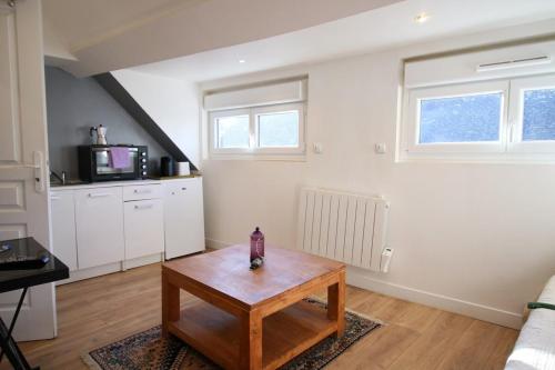 un salon avec une table basse et une cuisine dans l'établissement Le Petit Nid en plein centre-ville de Rouen !, à Rouen