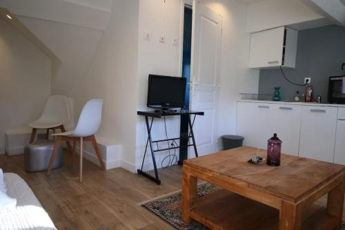 - un salon avec une table basse et une télévision dans l'établissement Le Petit Nid en plein centre-ville de Rouen !, à Rouen