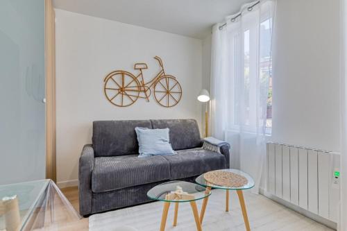 - un salon avec un canapé et un vélo sur le mur dans l'établissement Léandre studio entièrement rénové avec extérieur, à Rouen