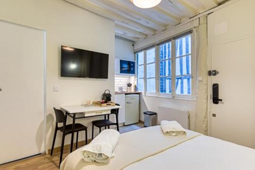 une chambre avec deux lits, une table et une cuisine dans l'établissement Petit Vicomte joli studio place du Vieux Marché, à Rouen