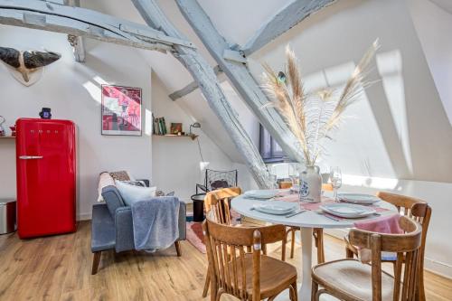 - une salle à manger avec une table, des chaises et un réfrigérateur rouge dans l'établissement Jules joli F2 proximité Gare en coeur de ville, à Rouen