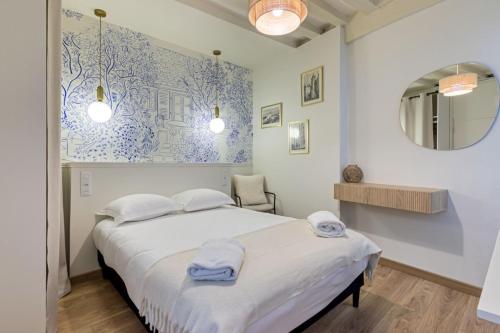 une chambre avec un lit et un miroir dans l'établissement Petit Vicomte joli studio place du Vieux Marché, à Rouen