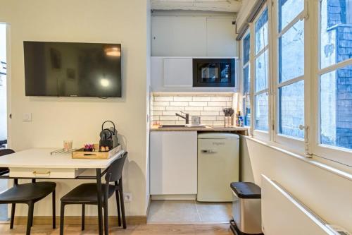 - une petite cuisine avec une table et un comptoir dans l'établissement Petit Vicomte joli studio place du Vieux Marché, à Rouen