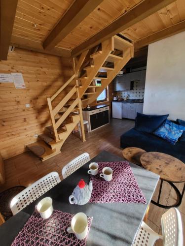 a living room with a table and chairs and stairs at DOMKI POD CHMURKĄ in Solina