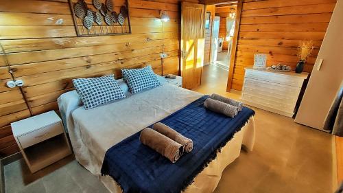a bedroom with a bed with blue sheets and pillows at Cabaña 99 by Villamya in El Gastor