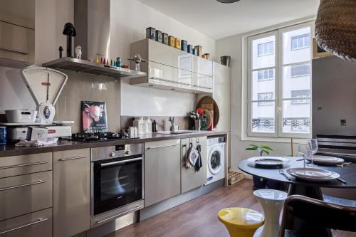 une cuisine avec des appareils en acier inoxydable et une table dans l'établissement Gérard appartement central avec parking privé, à Rouen