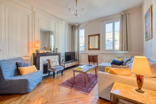 un salon avec des canapés bleus et une télévision dans l'établissement Fontenelle magnifique F3 Haussmanien à Rouen, à Rouen