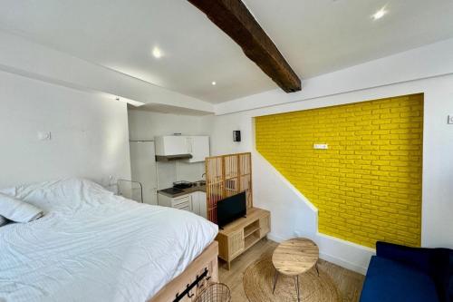 - une chambre avec un lit et un mur en briques jaunes dans l'établissement Sofia Studio confortable en RDC au coeur de la ville de Rouen, à Rouen