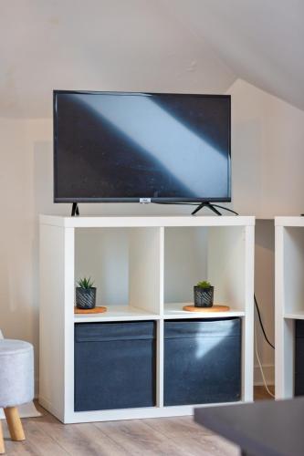 - une télévision à écran plat sur un centre de divertissement blanc dans l'établissement Le Cocoon appartement proche du Vieux Marché, à Rouen