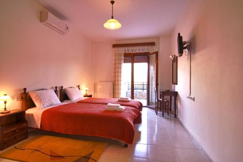 1 dormitorio con 1 cama con colcha roja en Aposeti Villas, en Petrochori