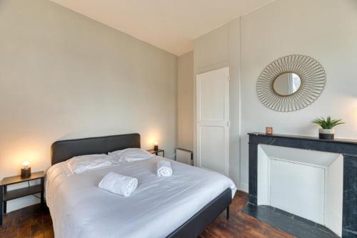 una camera con letto, camino e specchio di Le Rêve doré proche de la Gare ! a Rouen