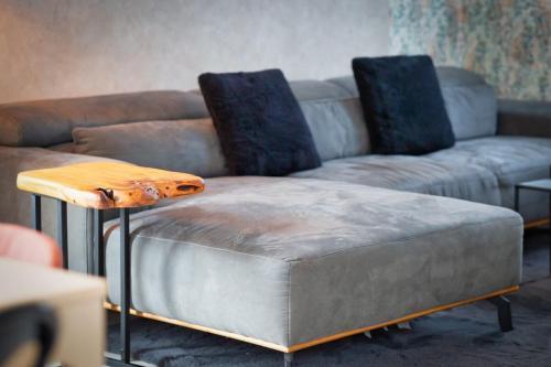 a couch and a ottoman in a living room at Amélie F5 avec stationnement in Val de Reuil