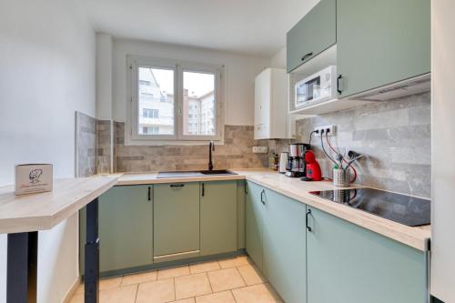 une cuisine avec des armoires bleues et un évier dans l'établissement Eric joli appartement rénové avec double balcons, à Rouen