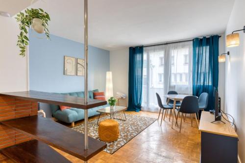 - un salon avec des murs bleus, une table et des chaises dans l'établissement Eric joli appartement rénové avec double balcons, à Rouen