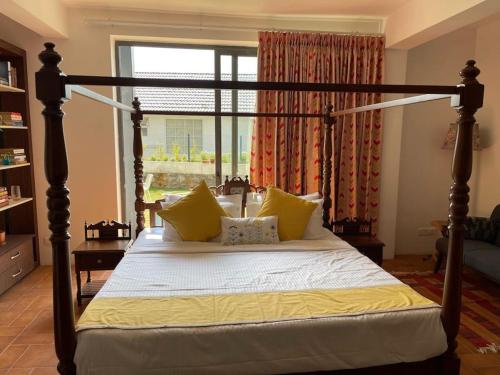 a bedroom with a large bed with yellow pillows at Shangrila Casa-Premium Homestay in Lovedale