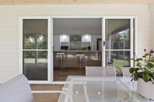 a patio with a table and chairs and a kitchen at Jetty Road Holidays - 33 Jetty Road in Normanville
