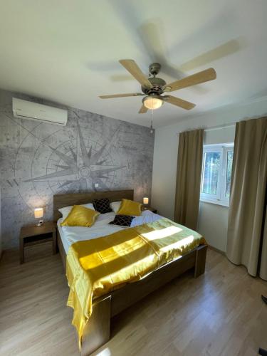 a bedroom with a bed with a ceiling fan at Villa Akulica in Jakišnica