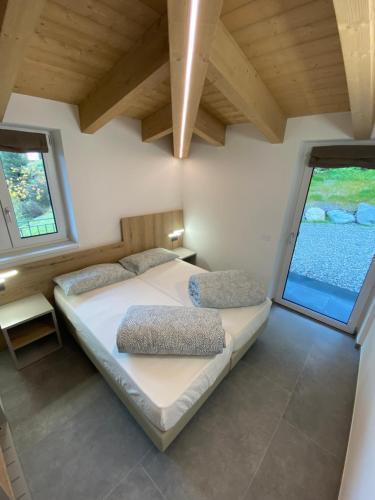 a bedroom with two beds and two windows at CA del BRENZ in Folgarida