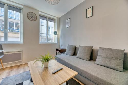 un salon avec un canapé et une table dans l'établissement Le Thibaut studio rénové au coeur de Rouen, à Rouen