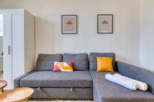 - un salon avec un canapé gris et des oreillers colorés dans l'établissement Mia Studio cosy proche place du Vieux Marché, à Rouen