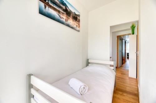 - un lit blanc dans une chambre ornée d'une peinture murale dans l'établissement Rollin appartement 3 personnes avec Netflix au calme !, à Sotteville-lès-Rouen