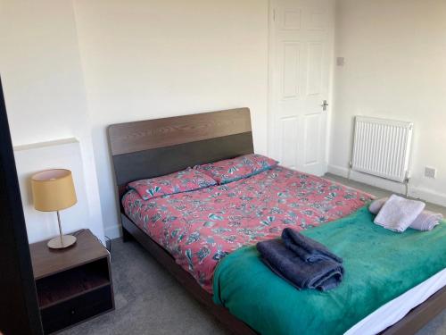 a bedroom with a bed with a green comforter at Leadenflower Apartment in Crieff