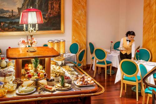 a woman standing in a room with a buffet of food at La Residenza in Rome
