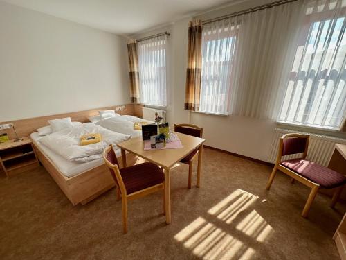 a hotel room with a bed and a table and chairs at Evangelisches Allianzhaus in Bad Blankenburg