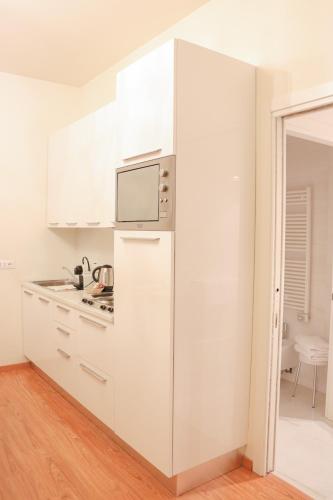 a white kitchen with a refrigerator and a microwave at Al Bailo Di Venezia in Venice