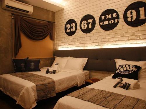 two beds in a hotel room with signs on the wall at The Shop Hotel in Kuala Kangsar