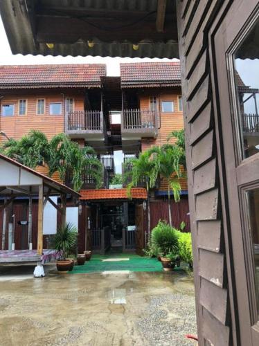 a courtyard of a building with palm trees and plants at Kampong Pinang Sebatang Melaka in Melaka