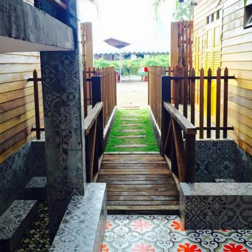 a wooden walkway with a fence and grass at Kampong Pinang Sebatang Melaka in Melaka