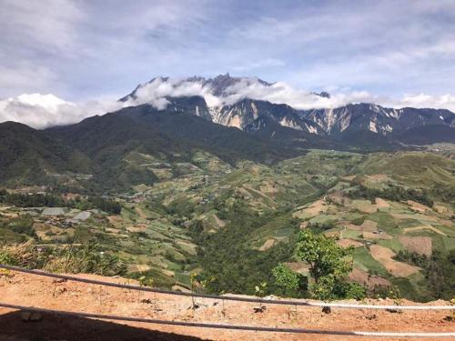 a view of a mountain range with clouds in the sky at Happy Village Kundasang in Ranau
