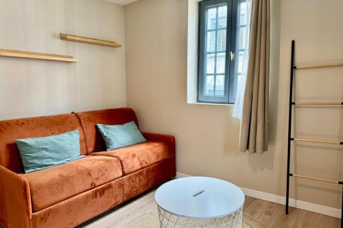 un salon avec un canapé et une table dans l'établissement Julia un véritable cocon au coeur de la ville, à Rouen