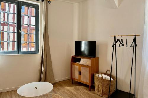 un salon avec une télévision sur un support en bois dans l'établissement Elisa studio contemporain au coeur de la ville, à Rouen