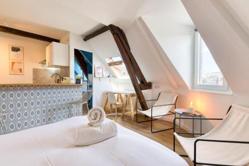 une chambre avec un lit et des chaises et une cuisine dans l'établissement Elisabeth Confortable studio avec lit double en centre ville, à Rouen