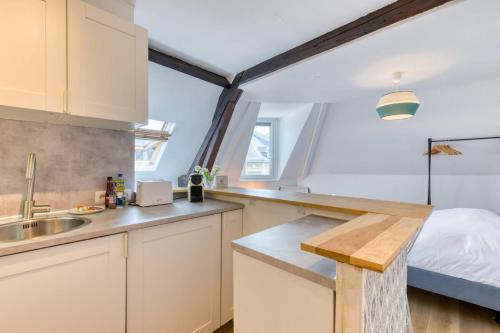 - une cuisine avec évier et un lit dans une chambre dans l'établissement Elisabeth Confortable studio avec lit double en centre ville, à Rouen
