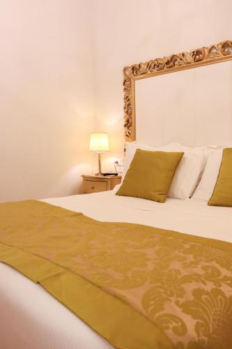a bedroom with a white bed with a gold headboard at Al Bailo Di Venezia in Venice