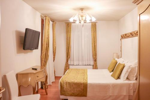 a small bedroom with a bed and a television at Al Bailo Di Venezia in Venice