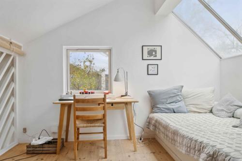 una camera da letto con una scrivania, un letto e una finestra di Cozy Holiday Home In Tisvildeleje a Tisvildeleje