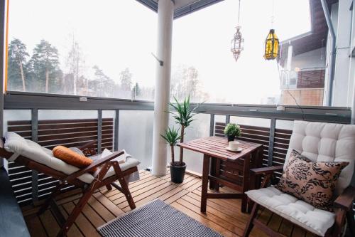 a balcony with a table and chairs on a porch at Romantic Sauna Retreat Near Sello and Nature Perfect in Espoo