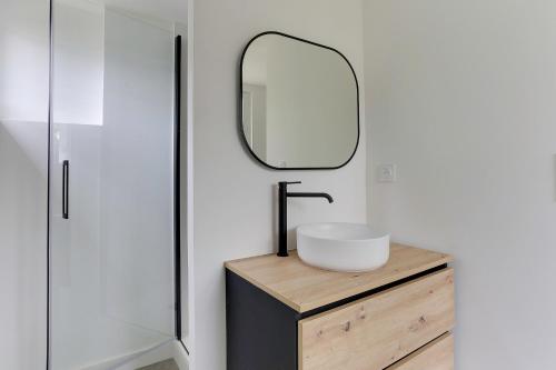 une salle de bain avec un lavabo et un miroir dans l'établissement Lancelot - appt 4 pers, à Bruz