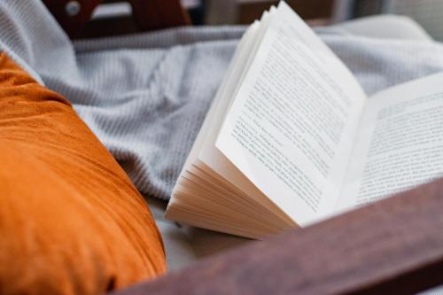 a book sitting on a table next to a pillow at Romantic Sauna Retreat Near Sello and Nature Perfect in Espoo