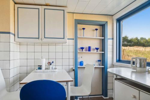 a kitchen with a table and chairs and a window at Cozy Summer House On Bornholm in Neksø