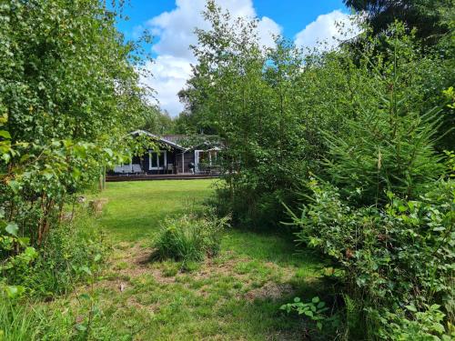a yard with trees and a house in the background at Large Child-Friendly Holiday Home North Sealand in Frederiksværk