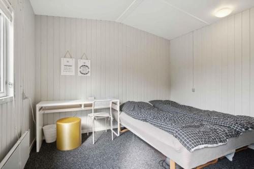 a room with two beds and a desk and a bed sidx sidx sidx at Lovely Summer House In Øster Hurup in Hadsund