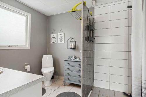 a bathroom with a shower with a toilet and a sink at Lovely Summer House In Øster Hurup in Hadsund