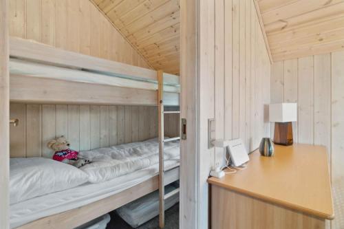 a teddy bear sitting on a bunk bed in a room at Cozy Holiday Cabin Near Grindsted in Grindsted